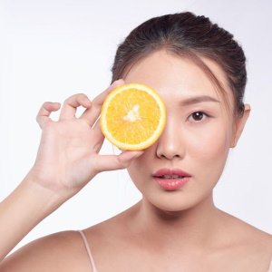 femme avec une orange devant les yeux